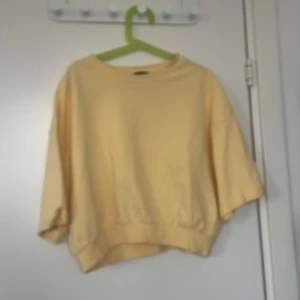 Gul croppad tröja från 157 - Säljer en ljusgul croppad tröja från 157 i storlek S. Tröjan har korta, vida ärmar och ribbade muddar vid hals och nederkant. Perfekt för dig som gillar en avslappnad och trendig stil.