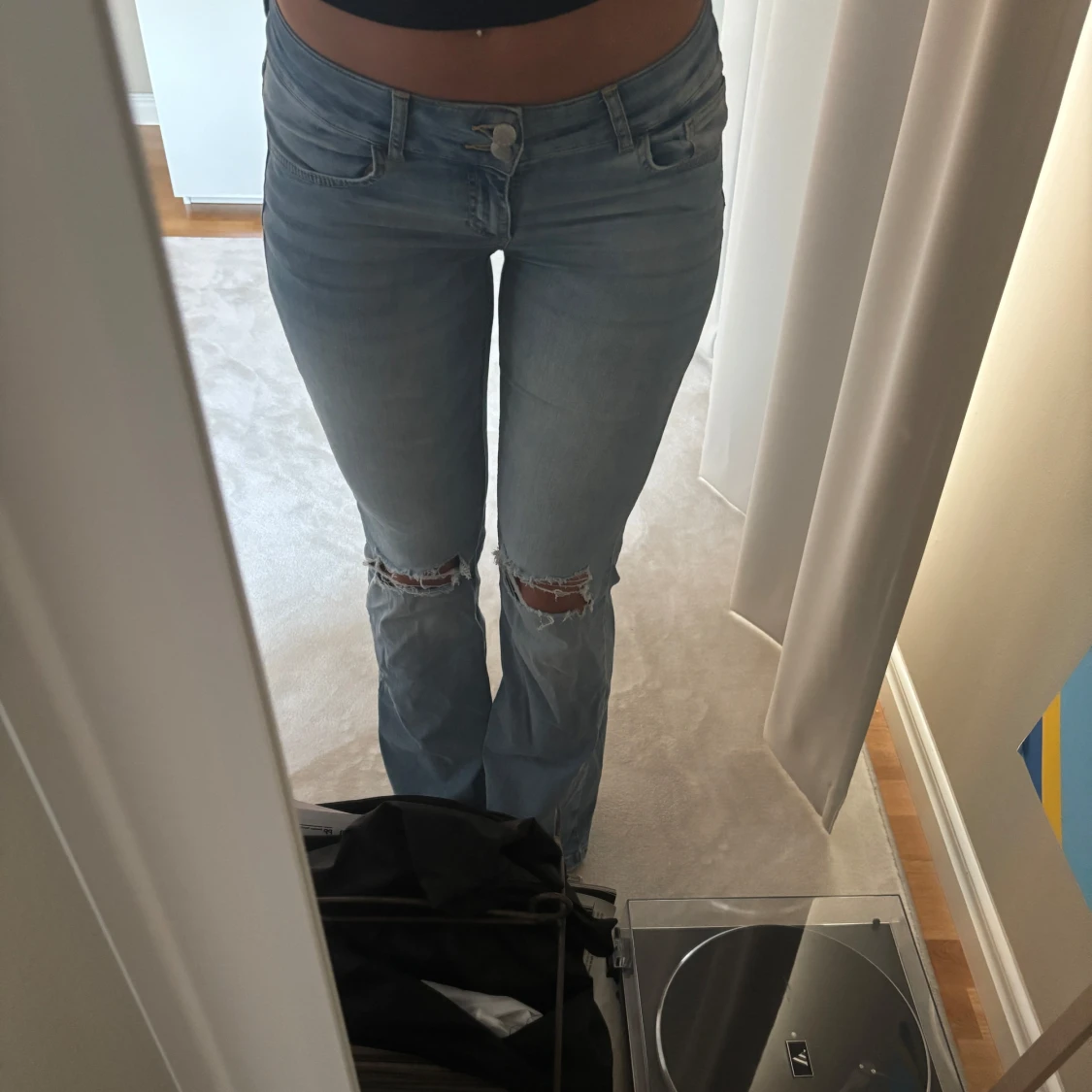 Ljusblå bootcut jeans med hål på knäna