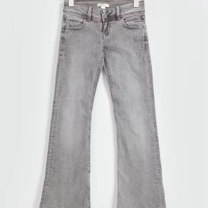 Grå bootcut jeans med stjärndetalj - Snygga grå jeans med bootcut passform och klassisk femficksdesign från Gina Tricot. Jeansen har en cool vit stjärna på bakfickan som ger en unik touch. Tillverkade i mjukt denimtyg som sitter skönt hela dagen. Jeansen i storleken 164, skriv för egna bilder!