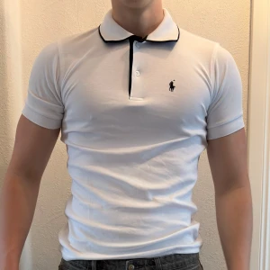 Vit polo t-shirt från Ralph Lauren - Vanlig vit ralph lauren piké. Tröjan är helt ny. säljer även ut andra saker från min gaderob så kolla gärna min sida och se om du hittar något du gillar!