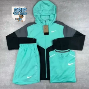 Nike vindjacka i turkos och svart - Snygg vindjacka från Nike i turkos med svarta och grå detaljer. Jackan har huva, hel dragkedja och vit logga på bröstet. Perfekt för träning eller chill, lätt och sportig look. Matcha med shorts och t-shirt för en komplett outfit.