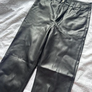 Svarta skinnbyxor från Gina Tricot - Säljer ett par svarta skinnbyxor från Gina Tricot i storlek 34. Byxorna är raka i benen. Det är lite för stora på mig därav säljer jag dom. Det är använda ett fåtal gånger men byxorna har lite märken som syns på bild 3 men det är inget som syns. Skriv privat för mer bilder
