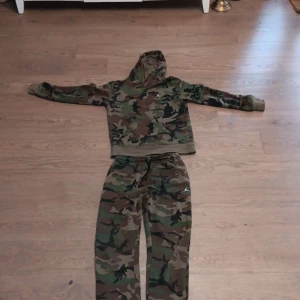 Camo mjukisbyxor från Jordan - Säljer ett par mjukisbyxor från Jordan i klassiskt camouflage-mönster. Byxorna har resår och snörning i midjan samt ribbade benslut. Perfekta för en avslappnad stil och streetwear-vibe.