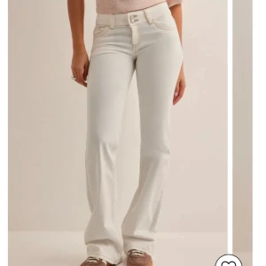 Vita bootcut jeansbyxor med broderade bakfickor - Säljer dessa trendiga jeans från Nelly🤍Endast använda 2 gånger så i bra skick!!!