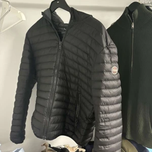 Svart dunjacka från Colmar - Snygg svart dunjacka från Colmar med dragkedja och huva. 