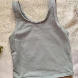 Grön grå linnetopp - Säljer en enkel och stilren grön grå linnetopp med rund halsringning. Perfekt för varma dagar och lätt att matcha med olika outfits.