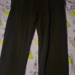 Svarta mjukisbyxor med resår i benslut - Svarta mjukisbyxor med resår i bensluten och dragsko i midjan. Perfekta för chill eller träning. Klassisk rak passform och mjukt material som känns skönt mot huden.