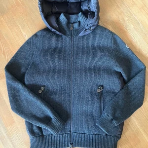 Moncler cardigan - En sällsynt Moncler cardigan i väldigt bra skick. Inga defekter vad jag kunnat hitta, enda anmärkningen är tagsen som visas på bilderna. Storlek XL och i en snygg grå färg