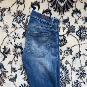 Dondup George Jeans - Säljer ett par snygga sällsynta blå jeans från George i otroligt bra skick. De har en cool slitning på ena benet och klassiska femficksdetaljer. Perfekta för en avslappnad stil med en touch av edge. Passar både till vardags och fest! Dem är i skick 9/10 och passar perfekt för folk som är ca 175! Riktigt feta och jag har använt dem ungefär 2 gånger sen jag köpte och på det kommer det ultimata priset! Dom är ca 100cm långa! Tveka inte att höra av er vid frågor 📦🙌
