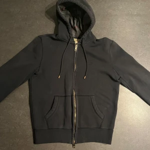 Burberry zip hoodie - Burberry zip hoodie i använt skick, den är lite urtvättad i materialet, finns ett slitage och en liten fläck, storlek S. 