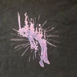 Svart t-shirt med lila tryck - Cool svart t-shirt med ett unikt tryck inspekterat från serien euphoria . Tillverkad i 100% bomull och har en klassisk passform med korta ärmar. Perfekt för dig som vill sticka ut med din stil.