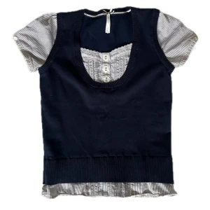 Mörkblå stickad tröja med randig skjortdetalj - Snygg blå stickad tröja med kortärmade, vit- och svart-randiga skjortärmar och knappdetaljer framtill. Minimala defekter syns i bilder ❣️