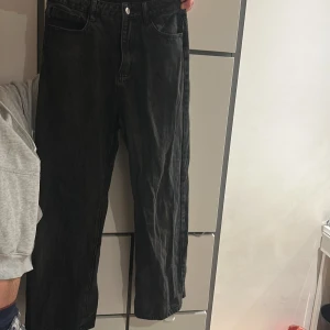 Svarta raka jeans - Säljer ett par svarta jeans med rak passform och klassisk femficksdesign. Jeansen har hög midja och stängs med knapp och dragkedja. Perfekta till en avslappnad stil och passar till det mesta.