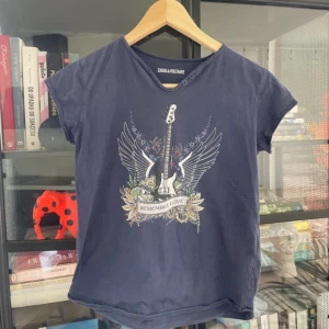  Zadig & Voltaire T-shirt med tryck - Mörkblå t-shirt med coolt tryck av elgitarr, vingar och blommor samt texten 'Remember Love'. I storlek 12y.  Perfekt för sommaren!💕☺️☺️