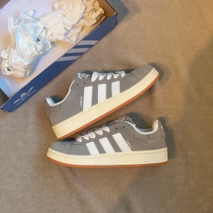 Adidas Campus 00s - Grå - Adidas campus 00s i grå. Passar storlek 38. En av dem trendigaste skorna till sommaren. Skorna är i ny skick. Nypris 1499 vårt pris 849kr📍  Hör gärna av er vid frågor!