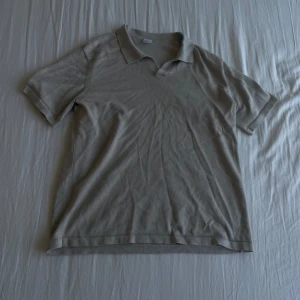 Beige pikétröja från Lindex - Säljer en stilren beige pikétröja från Lindex med klassisk krage och korta ärmar. Perfekt för en avslappnad och snygg look. Passar dig som gillar enkel och tidlös stil.