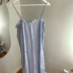 Blåvit randig klänning från H&M - Säljer en söt blåvit randig linne klänning från H&M i storlek XS men skulle säga att den passar en M också då den är stor i storlek🤍