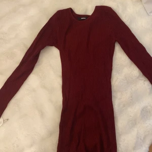 Vinröd ribbad klänning från Bik Bok - Säljer en vinröd ribbad klänning från Bik Bok i storlek S. Klänningen har lång ärm, rund halsringning och är figurnära i modellen. Perfekt för dig som gillar en enkel men stilren look.  