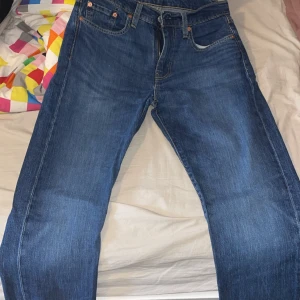 Levi's 502 blå jeans - Klassiska blå jeans från Levi's modell 502 med raka ben och normal passform. Jeansen har fem fickor, dragkedja och knapp i midjan samt tydliga kontrastsömmar. Perfekta för en avslappnad stil.