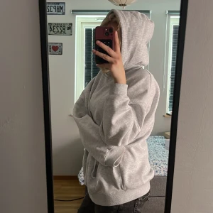 Ljusgrå oversized hoodie - Säljer en super skön och mysig ljusgrå hoodie med en perfekt luva och känguruficka. Tröjan har en oversized passform och är perfekt för en avslappnad stil. Mjuk och skön, passar till det mesta. Ny pris 300 kr så säljer för 200!