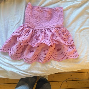 Rosa volangkjol  - Supersöt rosa kjol med två lager volanger. Kjolen har hålmönster och är perfekt för sommaren. 