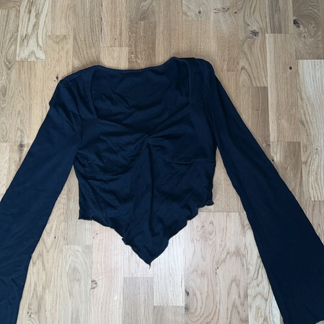 Svart långärmad topp med asymmetrisk nederkant - 1