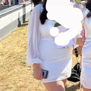 Vit kortklänning med transparenta ärmar - Säljer en vit kortklänning med långa, transparenta ärmar och figurnära passform. På andra bilden ser den lite rosa ut men är egentligen cream vit som på första bilden. Perfekt till skolavslutningen💗