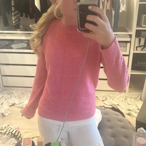 Rosa stickad tröja från Vero Moda - Säljer en söt rosa stickad tröja från Vero Moda. Tröjan har rund halsringning, långa ärmar och ribbade muddar vid ärmslut och nederkant. Perfekt för att liva upp garderoben med en färgklick! ALDRIG ANVÄND ENDAST TESTAD