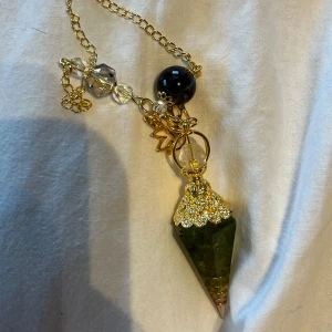 kristall pendant - pendant med grön kristall i spetsig form, dekorerad med guldfärgad metall och kristaller. Oanvänd.