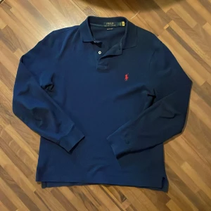 Ralph lauren långärmad piké  - Marinblå långärmad Ralph lauren piké. Custom slim fit. Strl S men passar även M. Bra skick. Skriv privat för frågor.
