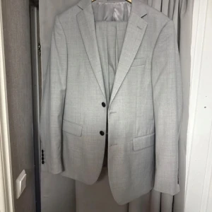 Ljusgrå kostym från Dressmann - Säljer en riktigt schysst kostym från dressmann i nyskick. Köptes för ca. 2000kr och är endast använd 1 gång så den är sågott som helt ny. Hör av er vid frågor eller om ni vill diskutera fram ett pris!