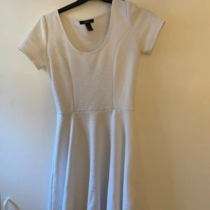 Vit kortärmad klänning från Forever 21 - Säljer en söt vit klänning från Forever 21 med korta ärmar och rund halsringning. Klänningen har en lätt utställd kjol.  Perfekt för sommarens alla tillfällen! Kontakta vid frågor eller prisförslag!