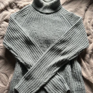 Stickad grå polo  - Mysig grå polotröja från Jacqueline de Yong i grovstickat material. Tröjan har lång ärm, hög polokrage och en relaxed passform som är perfekt för kyliga dagar. Enkel att matcha med jeans eller kjol för en chill look🩶