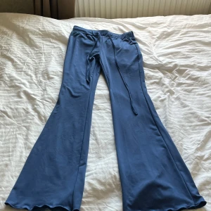 Blå bootcut mjukisbyxor från SHEIN - Säljer ett par blå mjukisbyxor från SHEIN i storlek XS. Byxorna har bootcut-modell med utsvängda ben och dragsko i midjan. Perfekta för en avslappnad stil och superbekväma att ha på sig.