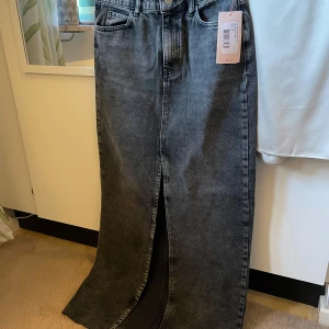 Grå lång jeanskjol från Nelly - Säljer en snygg lång grå jeanskjol från Nelly. I nyskick med prislappen kvar. Odrinariepris 599kr, säljer för 300 men pris kan diskuteras såklart💕💕