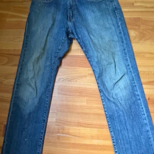 Blå jeans från US-Top Denim, 32/30 - Klassiska blå jeans från US-Top Denim med raka ben och normal passform. Jeansen har fyra fickor, snyggt sliten tvätt och patch bak i midjan. Perfekta för dig som gillar en tidlös denimlook. Hör av er med funderingar!