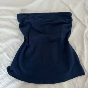 Mörkblå tubtopp från Esmara - Säljer en enkel och stilren mörkblå tubtopp från Esmara. Perfekt att matcha med jeans eller kjol. Toppen är ärmlös och har en mjuk, stretchig känsla. Finns stickigt band så den sitter bra!