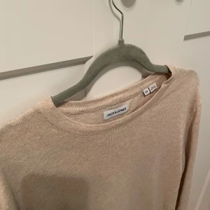 Beige skön tröja från Jack & Jones - Säljer en stilren beige skön tröja från Jack & Jones. Perfekt för en avslappnad look. Tröjan har en enkel design med rund hals och är tillverkad i ett mjukt material. Helt oanvänd! Nypris:899kr, bara höra av sig vid frågor!