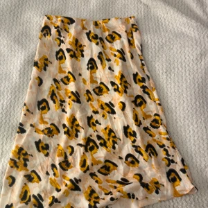 Leopardmönstrad kjol från Lindex M - Snygg kortkjol från Lindex med leopardmönster i gult, svart och beige. Kjolen har en rak passform och är gjord i ett lätt och mjukt polyestertyg. Perfekt för dig som vill sticka ut med ett coolt djurmönster.