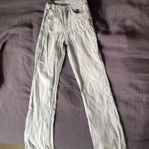 Ljusgrå jeansbyxor  - Säljer ett par ljusgrå jeansbyxor i storlek 164. Normal passform. Perfekta för dig som gillar en enkel och stilren look.de har tre hål två vid bak fickorna och ett där man knäpper men tror inte det syns när man har på sig de🤍🩶