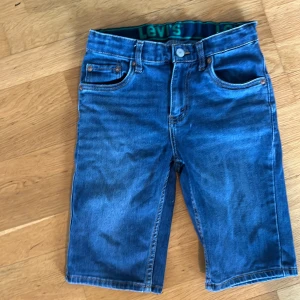 Blå jeansshorts från Levi's 152 cm - Tjena, säljer snygga blå jeansshorts från Levi's med klassisk. Shortsen har normal passform och är tillverkade i mjukt denimtyg. Perfekta för sommardagar och har en tidlös look med Levi's-logga bak.