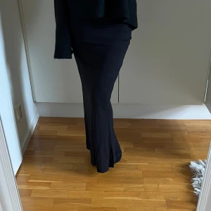 Svart långkjol  - Säljer en svart långkjol med snyggt fall och figurnära passform.