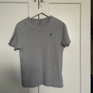 Grå Ralph lauren t-shirt  - Vi säljer en grå t-shirt i storlek S från polo Ralph lauren. Vi säljer T-shirten för ett billigt pris medans tröjan är i topskick. Pris kan diskuteras vid en snabb och smidig affär 