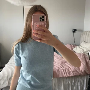 Ljusblå stickad kortärmad tröja - Säljer en ljusblå stickad tröja med korta puffärmar. Tröjan har en rund halsringning och är mjuk i materialet. Inte använd mycket och i ull.