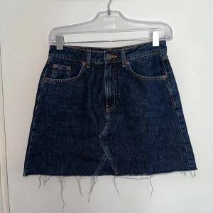 Mörkblå jeanskjol  - En snygg vintage mörkblå jeanskjol från Uncle Denim med klassisk femficksdesign och fransig nederkant. Kjolen är i stl. S och passar (36/38). Perfekt för sommaren! 💙