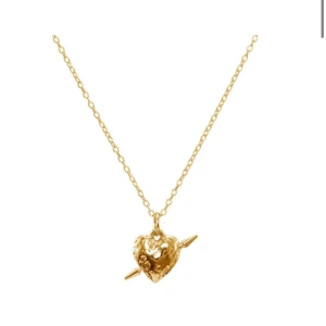 INTRESSEKOLL Guld Tuvestar Maria Nilsdotter  - Säljer ett snyggt halsband i guld med ett hjärta som har en pil genom sig. Kedjan är tunn och smidig, och hänget har en cool, lite rå yta. Perfekt för dig som gillar unika smycken med attityd. 