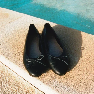 Svarta ballerinaskor med rosett - Säljer ett par klassiska svarta ballerinaskor från H&M. Helt oanvända och ändats testade, skorna har en rund tå och en söt liten rosett framtill