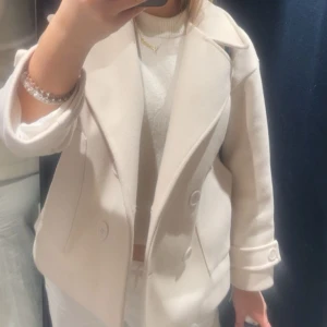 Kappa - Säljer min super fina ljus beiga kappa ifrån design by si i stl xs/s. Jackan är lite missfärgad på insidan av mörka jeans och lappen för att hänga upp den har gått sönder ( men inget som syns när man bär den ). Har kvar extra knappen man får, så den skickas med. Skriv för flera bilder eller hör av er vid frågor! 