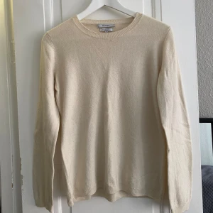 Kashmirtröja från El Corte Inglés - Säljer en elegant krämfärgad tröja i 100% kashmir från El Corte Inglés. Tröjan har en klassisk rund hals och långa ärmar, perfekt för en stilren look. Den mjuka kashmiren ger en lyxig känsla. Passar utmärkt för både höst och vinter.