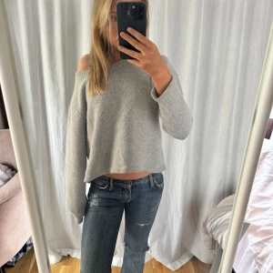 Grå offshoulder tröja - Säljer en stilren grå offshoulder tröja med lång ärm. Perfekt för en avslappnad look. Tröjan har en lös passform och är supermjuk. Storlek L men sitter mer som en s/m
